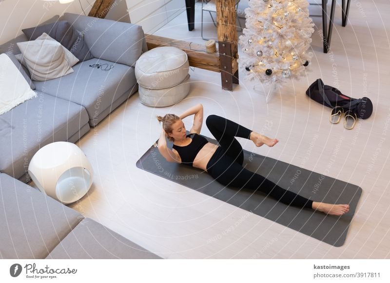 Beautiful blonde woman doing home workout indoors. Woman practice