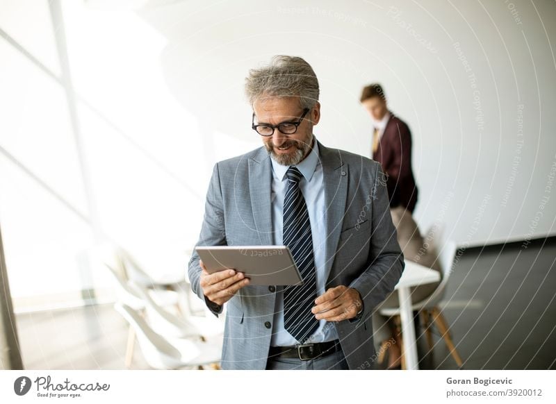 Handsome mature businessman using his tablet in the office adult age alone attractive businessmen businesspeople career caucasian confident contemporary