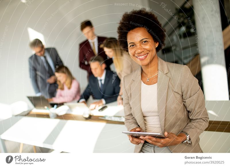 Beautiful female african american business woman CEO in a suit at the  workplace, standing confidently with arms folded Stock Photo