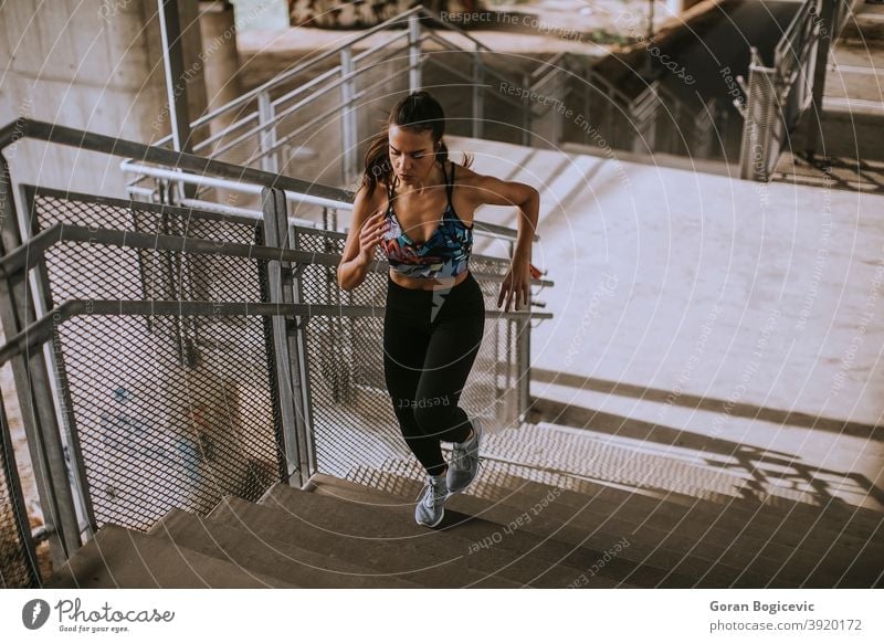 Young woman running in the urban environment stairs exercise training fitness female runner athlete workout city young lifestyle healthy person activity one