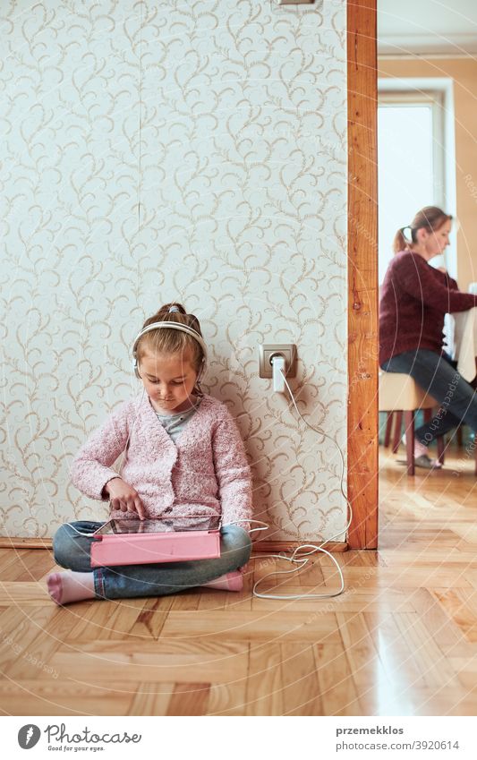 Little girl preschooler learning online solving puzzles playing educational games on tablet at home attention bed bedroom caucasian child childhood computer