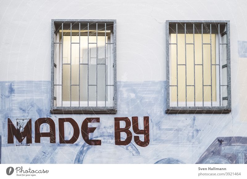 Graffiti on wall with windows Made by urban Window Grating Exterior shot Facade Wall (building) Deserted Colour photo Town Characters Architecture