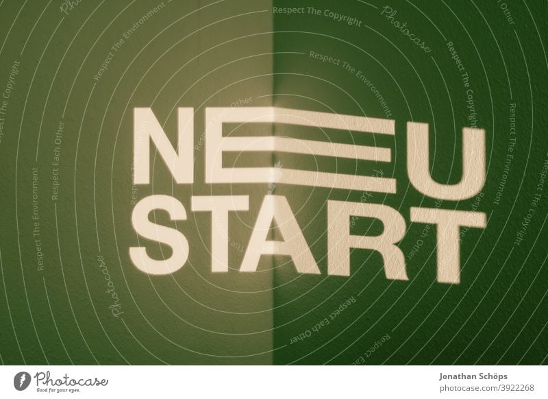 New start as font projection typographic on green Data projector Start of the year annual planning New Year Projection writing typography Wall (building) aims