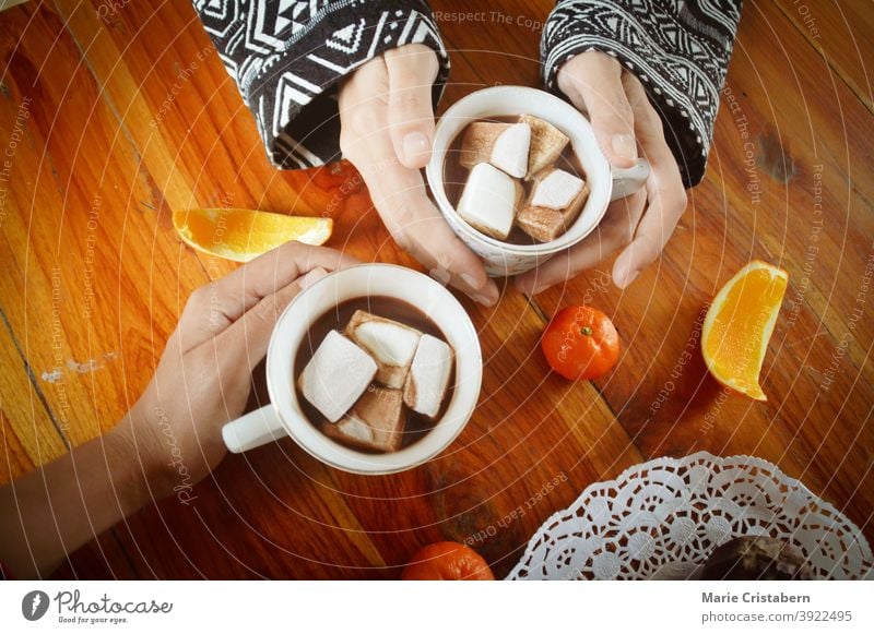 Sharing a cup og hot chocolate drinks with marshmallow on the Christmas morning new years eve togetherness human connection holiday marshmallows traditional