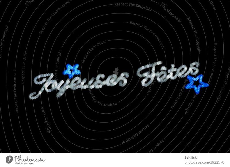 Text Joyeuses Fetes and blue stars out of focus with bokeh Christmas fairy lights Joyeuses Fêtes blurriness Silver Blue Light black background dazzle spots