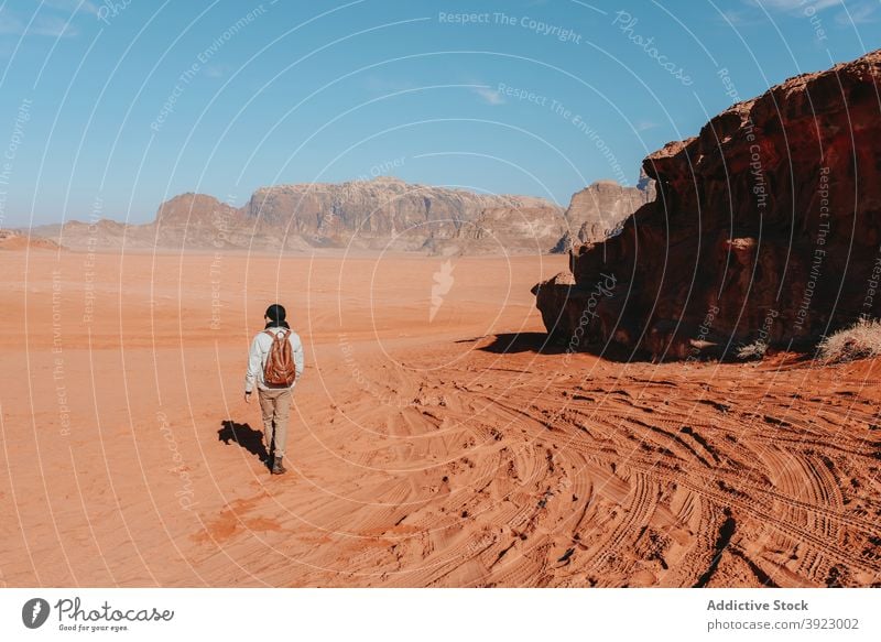 Anonymous traveler standing in desert with mountains during vacation sandstone valley explore tourist arid dry nature wanderlust wadi rum jordan outerwear