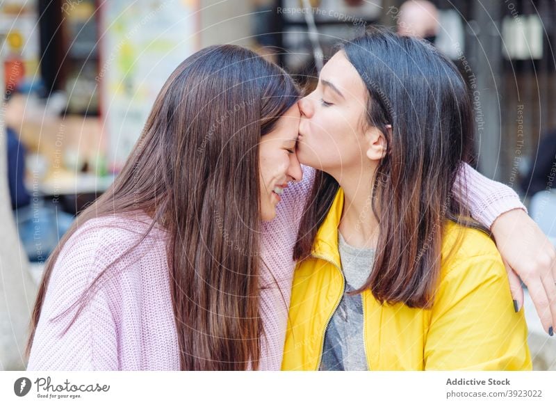 Couple of tender women kissing on street forehead lesbian couple lgbt love gay girlfriend bonding cuddle city weekend together relationship fondness happy