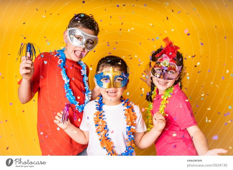 Three kids celebrating Carnival or New Years Eve at home background beautiful birthday boy cap carnival celebration cheerful child childhood children clothing