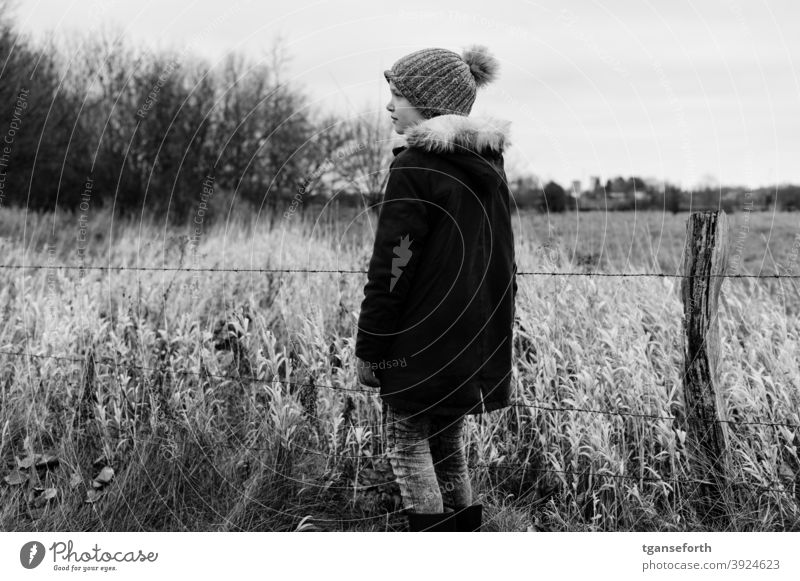 Child in front of an old pasture fence and bench Girl Human being 1 Pasture fence Barbed wire Barbed wire fence Catkin Exterior shot Meadow Barrier Colour photo