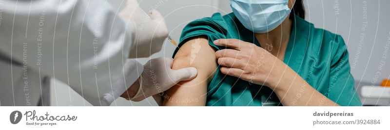 Female surgeon receiving coronavirus vaccine health personnel injection priority group doctor covid-19 banner web header panorama panoramic arm clinic medicine