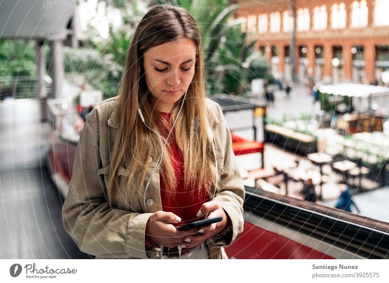 Young Girl With Headphones headphones girl portrait young 20s front view blonde pretty using phone cellphone caucasian looking standing woman female smartphone