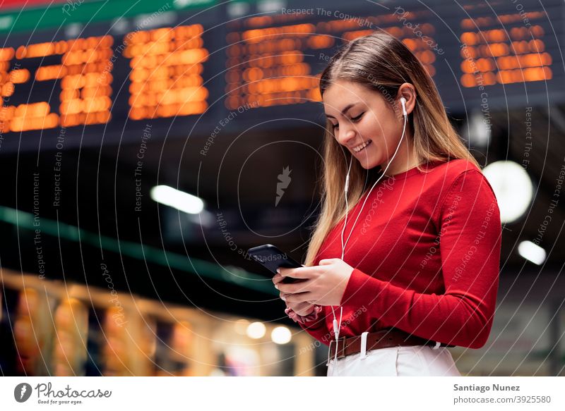 Girl in Train Station station train station side view looking at phone headphones girl portrait young 20s blonde pretty using phone cellphone caucasian standing