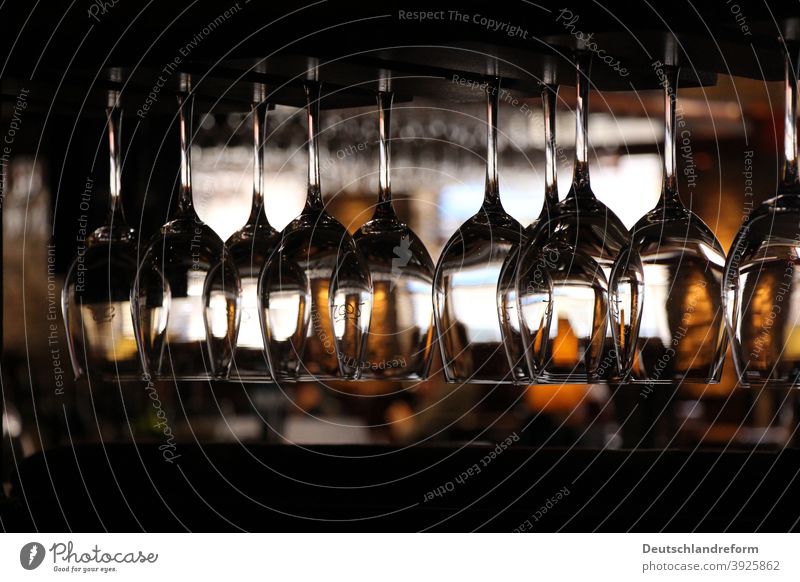 Close-up of wine glasses hanging on a shelf in dark surroundings of a restaurant Glass Light reflection Glasses structured Fragile Wine glass Vine Gastronomy