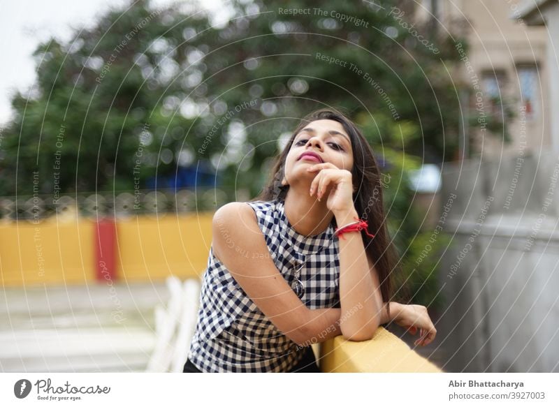 Fashion portrait of an young Indian Bengali brunette woman in black inner  wear and western jacket standing in front of a window in studio background.  Indian lifestyle and fashion photography. Stock Photo