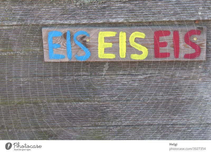 EIS EIS EIS - The word EIS handwritten in blue, yellow and red on a board on a wooden wall Ice Word Letters (alphabet) writing Handwriting Advertising