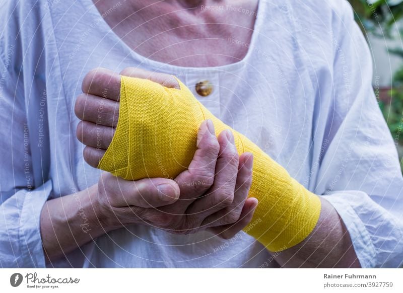 A woman has an injury on her wrist, she wears a yellow bandage violation Bandage Healthy Illness Accident at work absenteeism health insurance person Woman