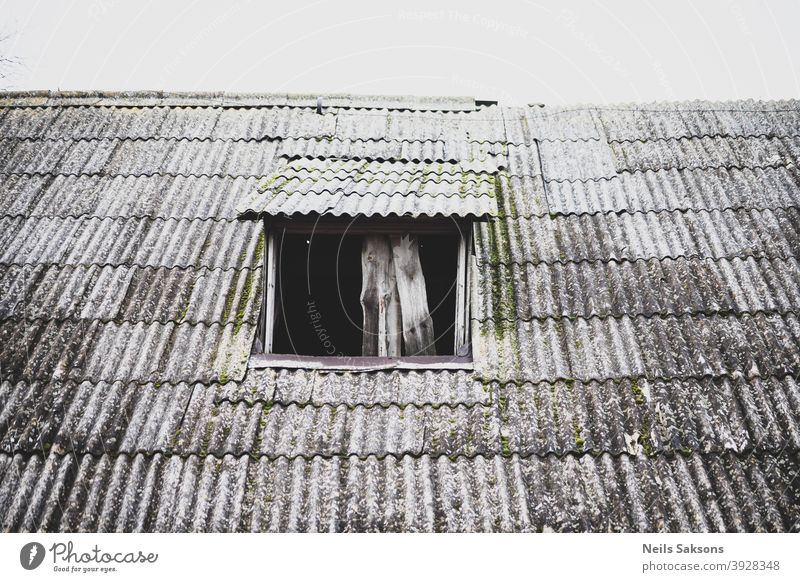 crooked wavy slate roof of old barn with roof window without glass Abstract aged architecture asbestos background built ceramic construction cover detail dirty