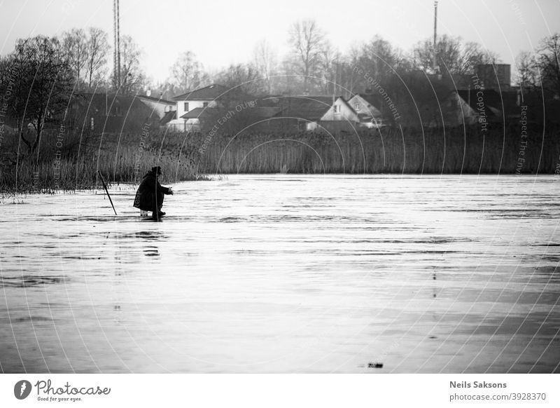 lonely fisherman on thin 5 cm ice. ice fishing is dangerous hobby. traditions in Latvia. Leisure and hobbies Catch Lake Lakeside Exterior shot River thin ice