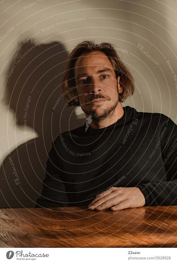 Portrait of a young man portrait Young man Sweater honestly atmospherically Wooden table Facial hair Moustache sincerely Modern fashionable naturally relaxed