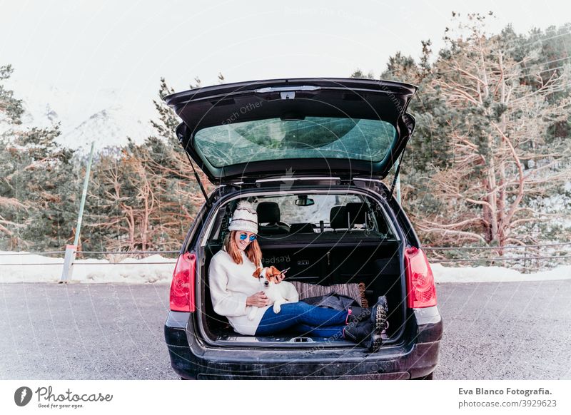 Woman and dog in car in the snow, winter time nature together season wanderlust beauty cute active togetherness friends day outside jack russell relaxation hug