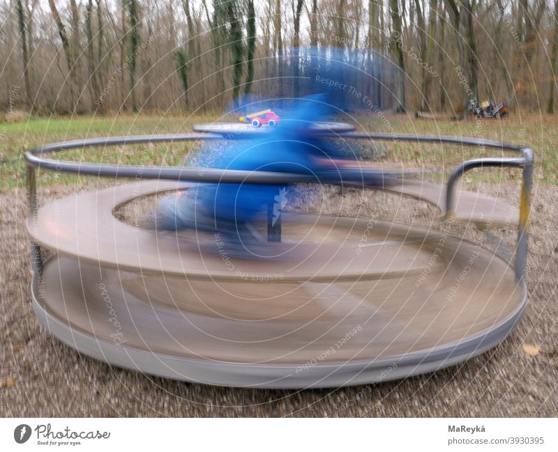 Kid spins on turntable in the forest playground and gets a spinning worm Rotate Potter's wheel Fire engine Playing woodland playground Playground Long exposure