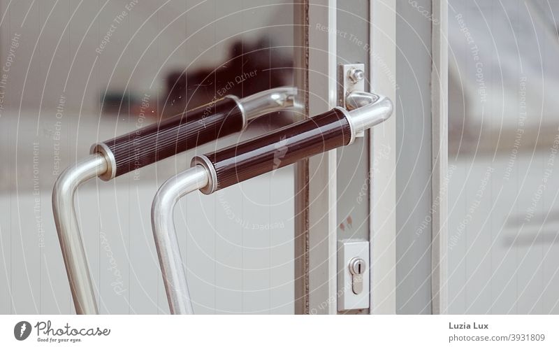 An old-fashioned shop door with a graceful handle bar, in delicate colours Door handle Handlebar Load Store premises daintily Old fashioned Curved Closed Trade