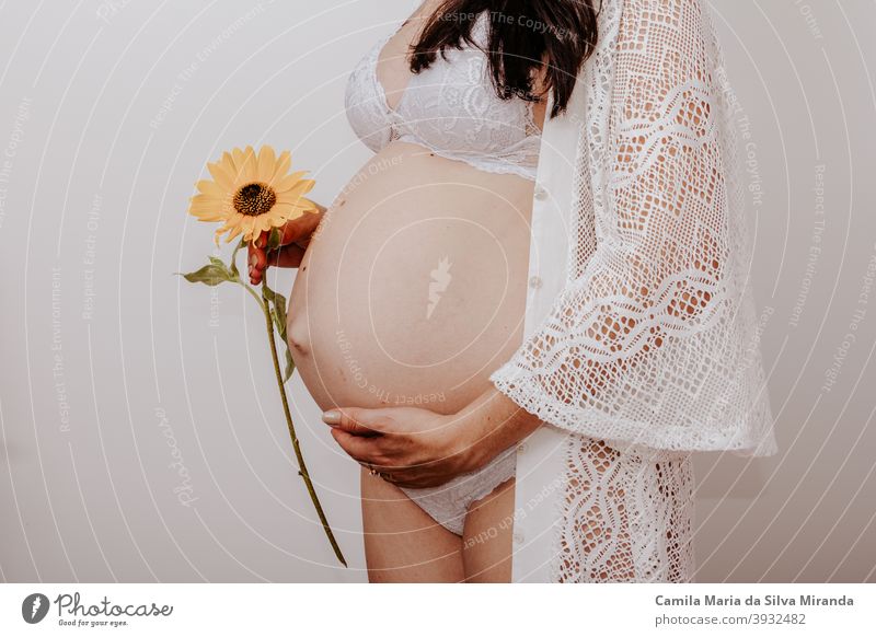 Pregnant woman holding a flower abdomen baby background beautiful beauty belly body bouquet copy space expectant family female flowers happiness healthy life
