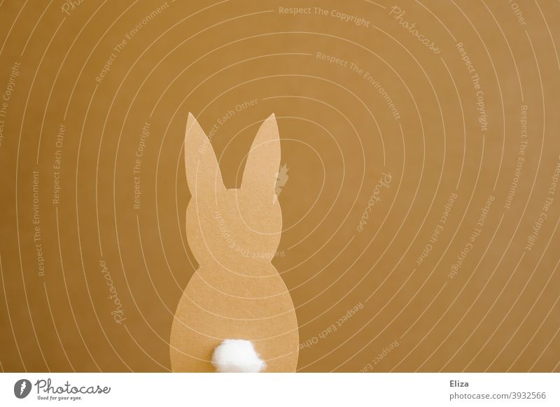 A paper Easter bunny on a yellow brown background Easter Bunny Paper silhouette Low-cut Handicraft Pushtail Hare ears rabbit Easter decoration Yellow Brown