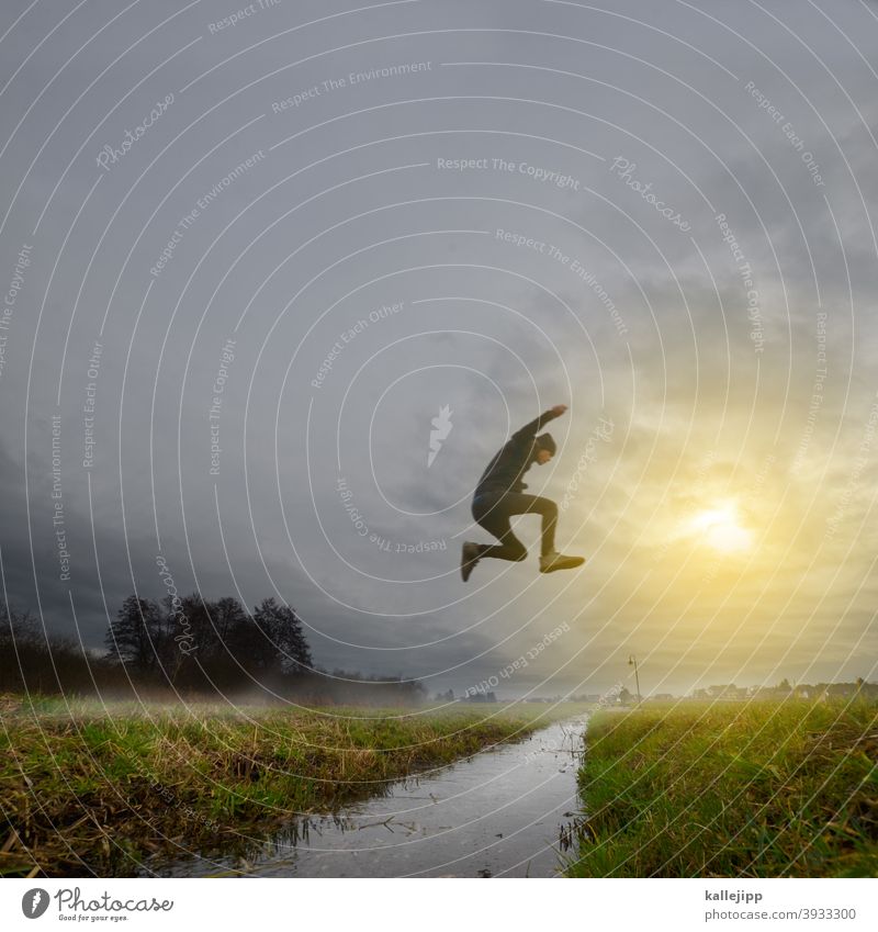 Old against New Jump jump Joy Man Sports Water Meadow Brook Nature Fog Shroud of fog Sky Clouds Exterior shot Colour photo Flying Action Light Landscape