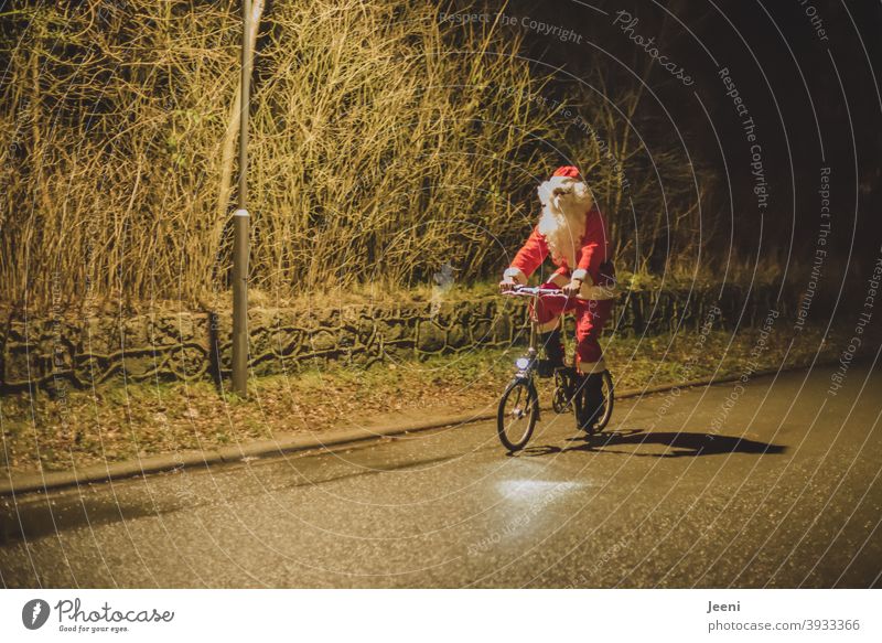 There he came cycling on Christmas Eve | Santa Claus on the bike | because there was no snow, he could not use the sleigh | with mouth-nose-protection because of the Corona-pandemic