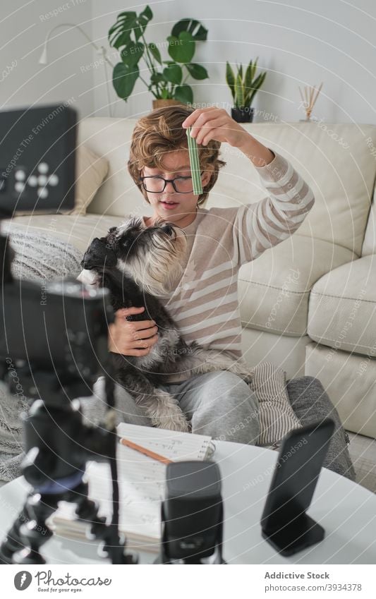 Young Boy Filming Video with his Dog playing playful dog feeding recording living room filming youtuber boy happy smiling cheerful having fun at home kid