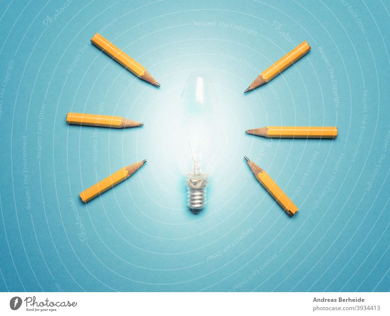 A glowing light bulb with 6 pencils as light rays, New ideas or creativity concept on blue background diversity team positive opportunity individuality finance