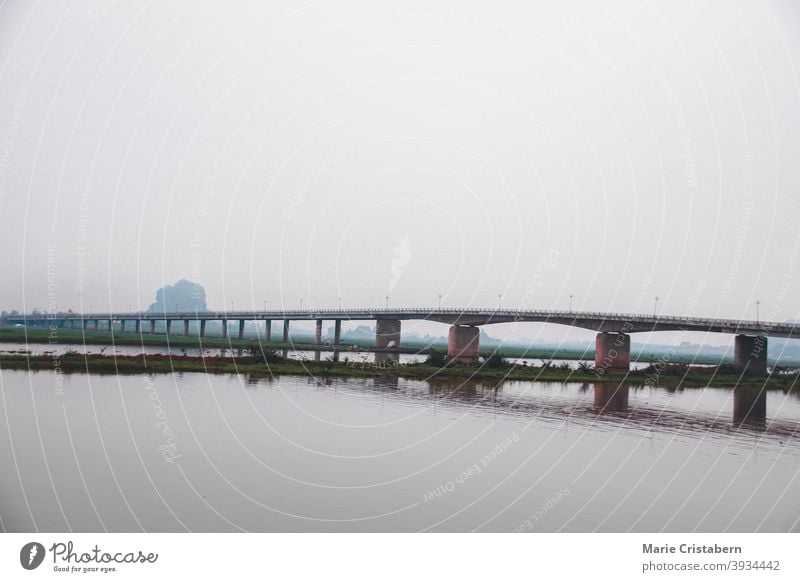 Cinematic scenery of a bridge over the river on a dark and moody day in Ninh Binh Vietnam solitude calm travel photography no people outdoors perspective beauty