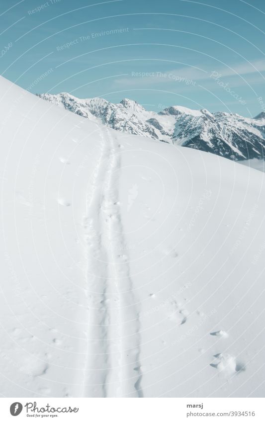 Ski track over snow cover. Target, the snow covered mountain peaks in the background Ski tracks Parallel Loneliness Cold Infinity Landscape Nature Frost Ice