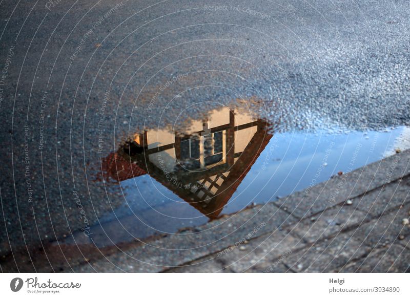 Gable of a half-timbered house as reflection in a puddle at the roadside House (Residential Structure) Building Half-timbered house Architecture Puddle Water