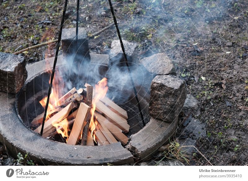 Lighting a campfire for cooking Fire Firewood Logs cooking fire Tripod start a fire Burn blaze fire up Ignite Hot Wood Fireplace Warmth Smoke
