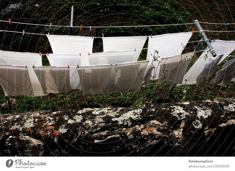 View over the wall to clotheslines with white sheets Laundry Washing Washing day Household Living or residing Clean Housekeeping Photos of everyday life White