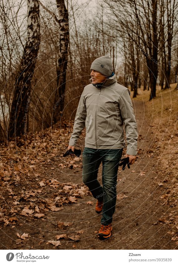 Sportlicher Rentner in der Natur beim spaziergen gehen spazieren natur outtdoor sport sportlich rentner alter mann portrait mütze winter kälte landschaft wald
