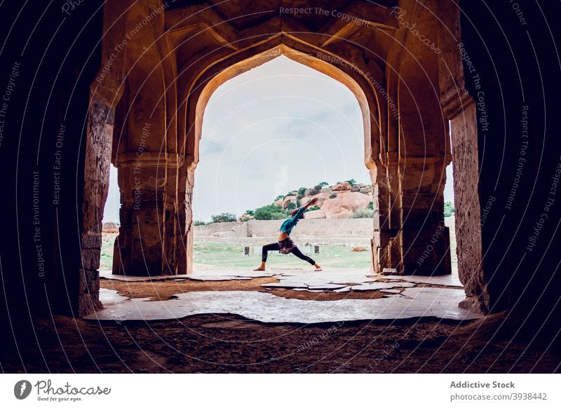 Anonymous lady practicing Virabhadrasana A yoga pose during outdoor training near historic palace woman virabhadrasana a warrior i zen mindfulness wellness