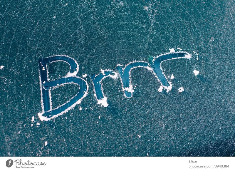 Brrr written on an icy car window. Cold winter. Winter chill Blue Freeze Car window authored Word Scratch iced icily freezing cold iciness Frozen Frost Ice