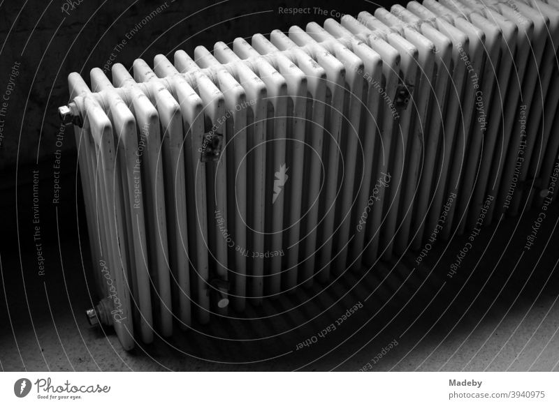 Discarded old radiator in the dark cellar of an old country house in Bavaria, photographed in classic black and white Heating Heater Warmth Old discarded Energy