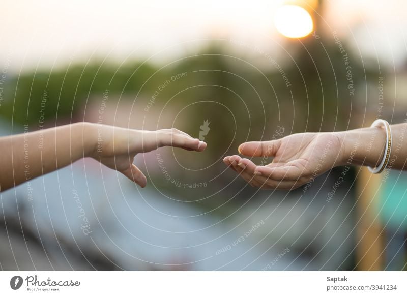 Child and woman reaching out to hold hands during sunset bonding togetherness calm mother daughter help assistance giving hope trust love peace finger symbolic