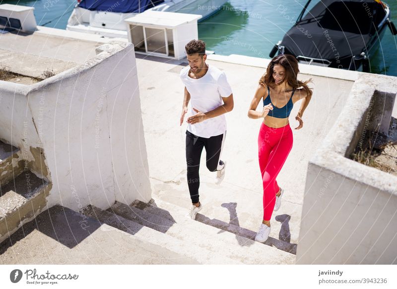 Young beautiful couple training together running outdoors - a