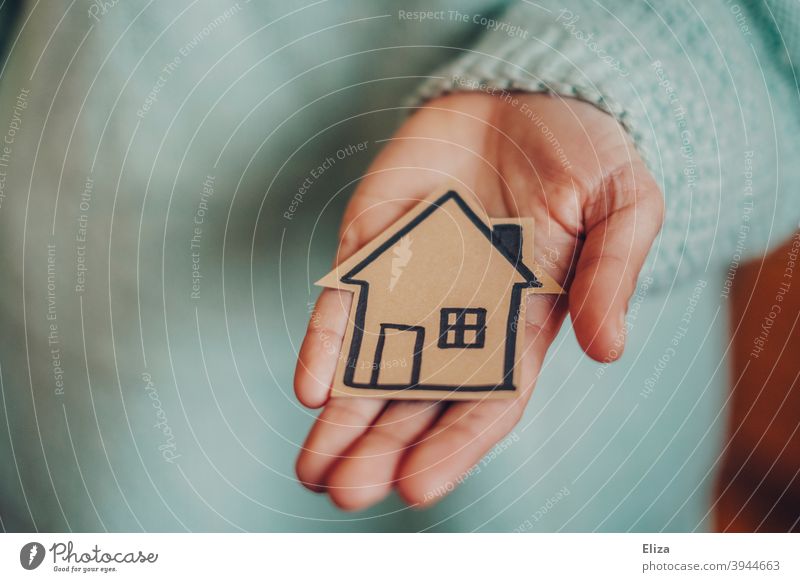 Hand holds a small painted house. Concept house construction and home ownership. House (Residential Structure) House building Home at home build a house