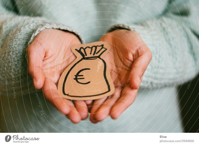 A person holds a painted money bag in his hands. Concept donor and donation. moneybags Donation Financial backer Give get Money finance investment Save spared