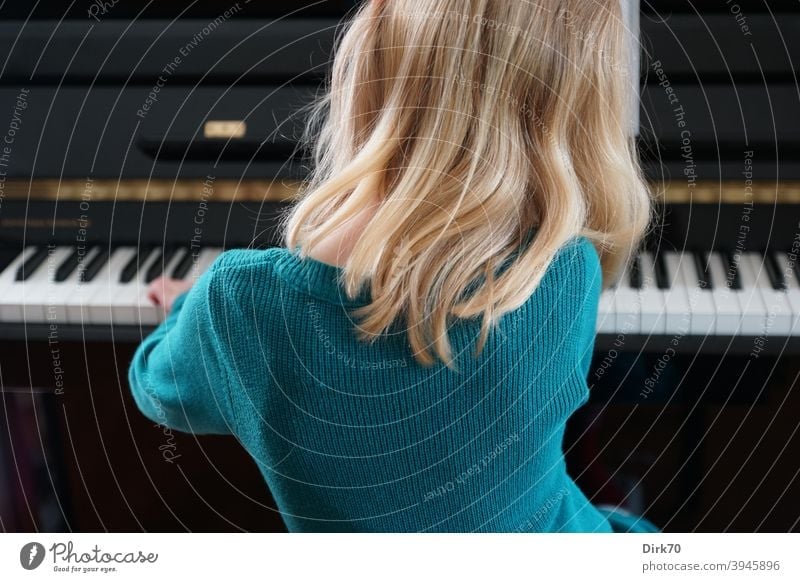 Little pianist - back view of blonde girl playing piano Girl Child Infancy Music Musician Piano Playing the piano piano player Keyboard Interior shot Make music