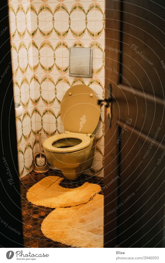 Retro toilet in bathroom Toilet john Flow nostalgically Nostalgia Bathroom Old Tile toilet brush Yellow Orange retro mood Old fashioned stale 1970s