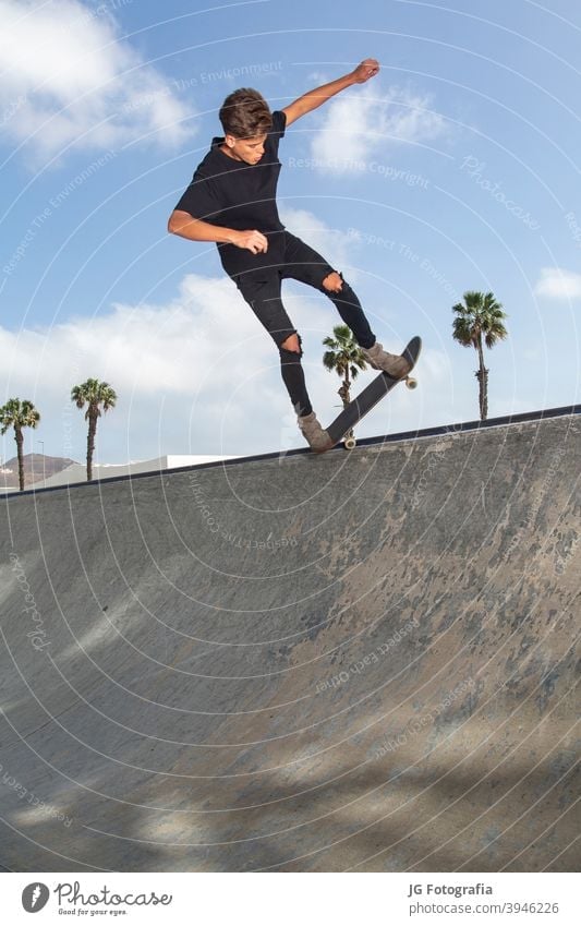 Young skateboarder performing tricks in a park, with street background and blue sky. young jump city lifestyle stunt male action active fun teenage fly urban