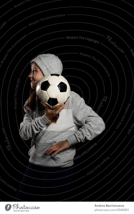 Little girl in gray sweatshirt and two pigtails playing with a soccer ball isolated on black background sport eye cut lifestyle joy beauty player young healthy