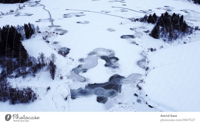 Aerial view with a drone of a frozen lake in Bavaria Aerial photograph drone photo Lake Body of water Frozen Ice Winter Snow Water circles Circle shape